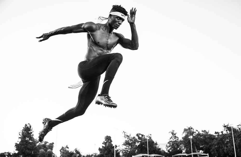 A man jumping in the air with his hands on his hips.