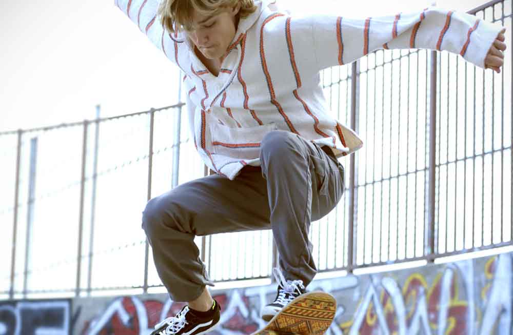 A man riding on the side of a skateboard.