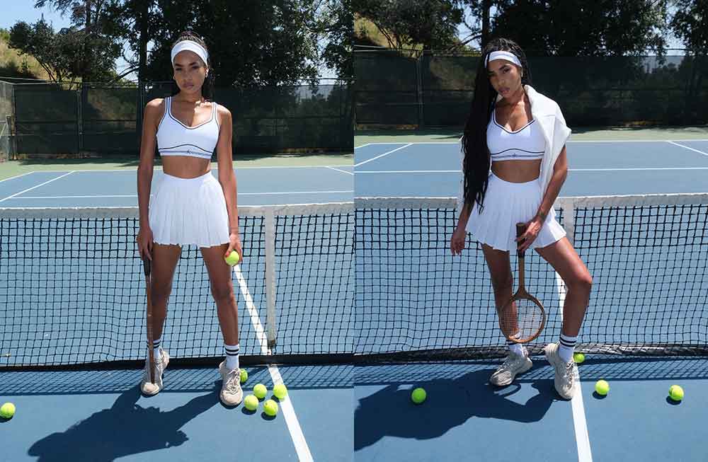 Two women in white tennis outfits on a court.