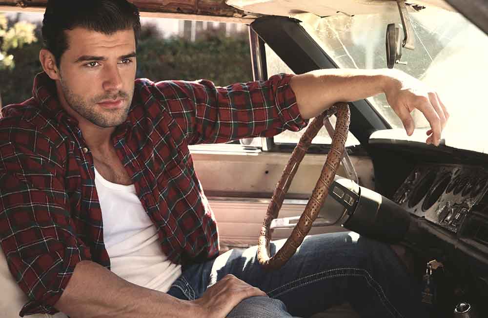 A man sitting in the driver 's seat of a car.