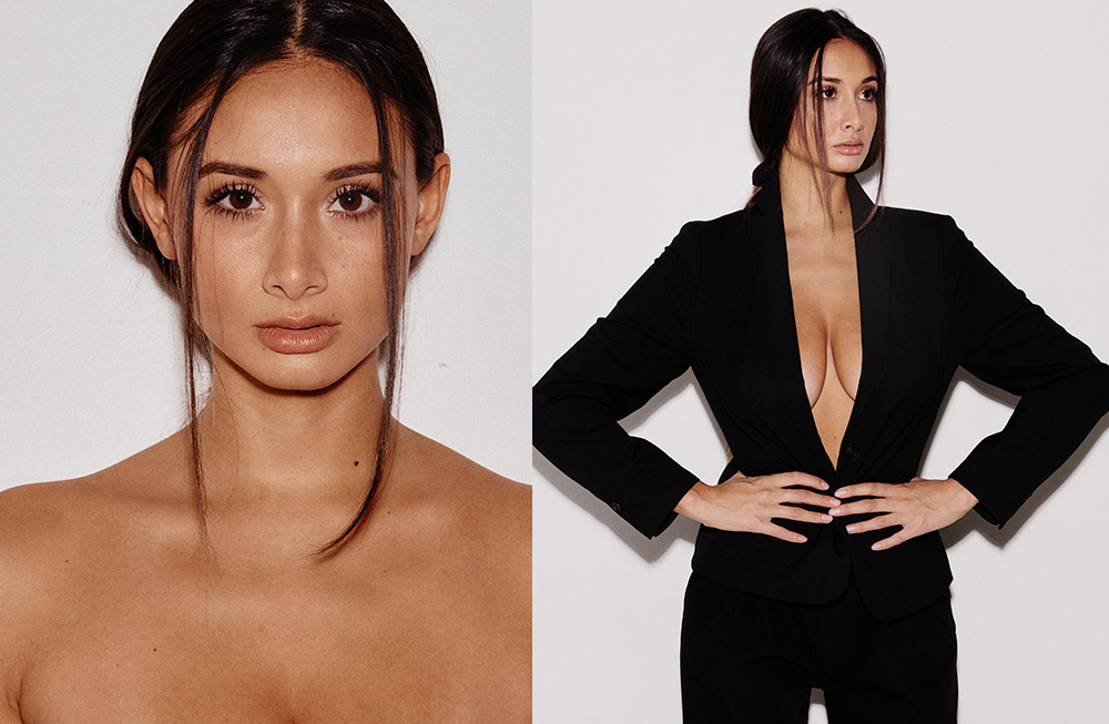 A woman with sleek hair and bold makeup poses confidently in a black outfit.